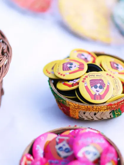 A basket of quirky, customized badges for the 'Ladke Wale' and 'Ladki Wale', a fun detail for the Mehendi ceremony.