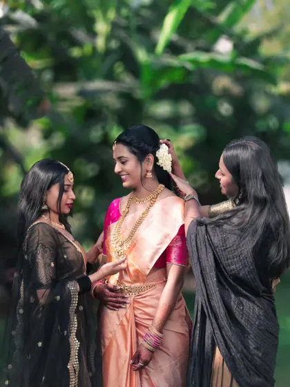 A candid moment showing the bride getting ready with the help of her friends. This photo captures the special bond and the happy, supportive atmosphere behind the scenes.