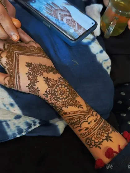 This photo captures me in action, creating a custom floral and mandala design for a client. You can see the reference photo on the phone, showing how I can replicate or adapt designs you love.