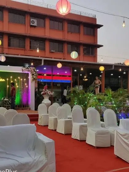 This is a wide view of an outdoor venue I decorated. You can see the guest seating arrangement with white covers, the main stage, and the hanging paper lanterns that create a festive mood for an evening event.