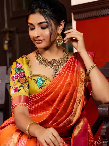 A close-up of Ragini's look, showing the exquisite detail of the hand-embroidered floral and butterfly motifs on her blouse.