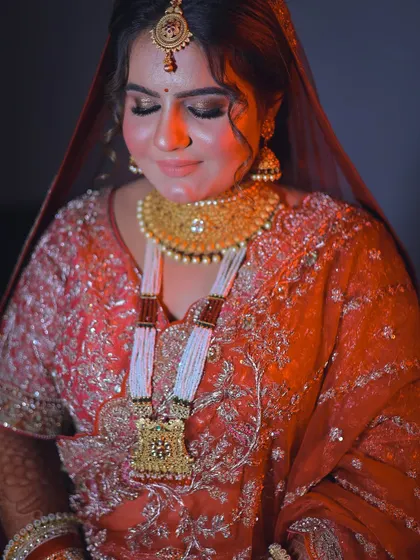 A serene portrait of the bride with her eyes closed, highlighting her intricate jewelry and makeup.