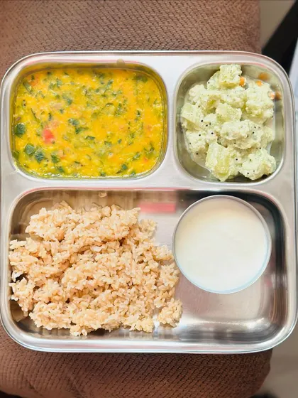 This light meal features broken wheat, dal palak, sautéed potato with poppy seeds, and a side of curd.