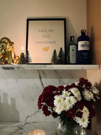 Getting into the holiday spirit at home. A little bar shelf styled with festive touches and, of course, a good bottle of gin.