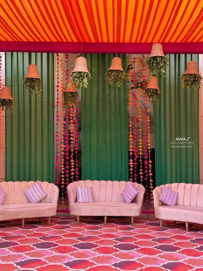The main seating area for the Mehendi, with comfortable sofas set against a backdrop of colorful drapes and a patterned floor.