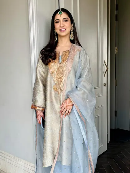 A full-length view of the beautiful baby blue phiran. The soft makeup and open hair complete this unique and elegant Mehendi look.