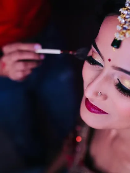 A detailed shot of the eye makeup application. I'm creating a beautiful blend of gold and purple eyeshadow for a unique touch on a traditional look.