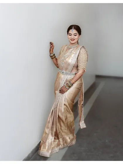 Another shot of this elegant bride. Her makeup is kept timeless to complement the shimmering golden saree and statement diamond jewelry.
