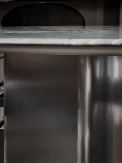 The sleek and reflective surface of the Stealth Dining Table's base, showcasing its modern and industrial-inspired design. This is where strength and style meet.