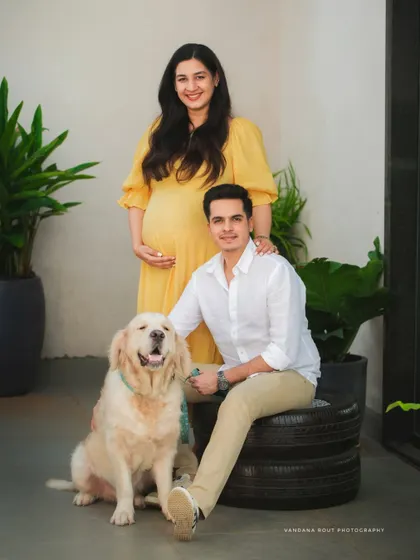 A formal family portrait with the couple and their handsome golden retriever, showing that pets are an important part of the family story.