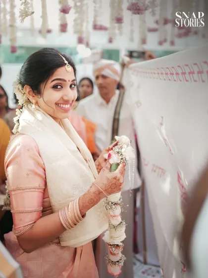 The bride's joyful expression as she holds the garland during the ceremony. Her happiness is infectious in this beautifully captured moment.