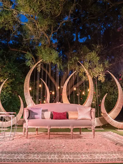 A unique and dreamy seating area with crescent moon-shaped backdrops and a plush sofa.