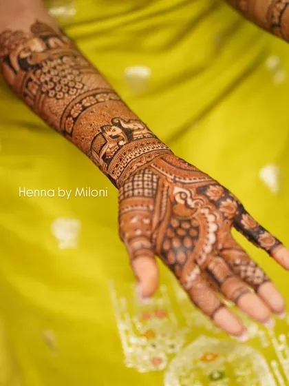 A close-up shot capturing the fine details of a bridal mehendi. The elephant and peacock motifs are drawn with precision and care.