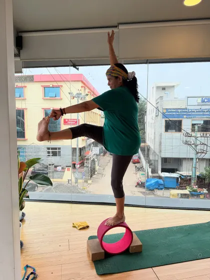 A student balances on a yoga wheel, demonstrating incredible focus and control. Wheel yoga is a great way to challenge your stability.