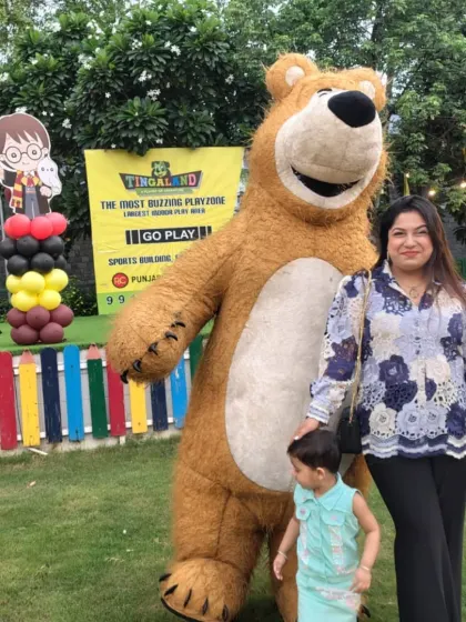 A guest gets a hug from a giant, friendly teddy bear at our outdoor venue. We have a variety of characters available to match different party themes and preferences.
