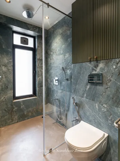 A calming blend of sage green and beige sets the tone for this timeless bathroom. The tiled shelves seamlessly merge into the walls, a conscious choice to maintain visual continuity and avoid cluttered lines.