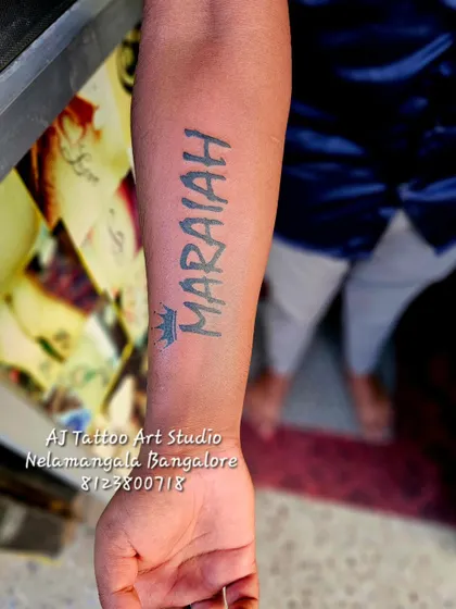 A "MARAIAH" name tattoo with a small crown, done in a strong block font.