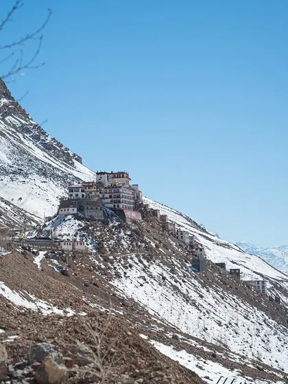 A distant shot of the Key Monastery, appearing like a fortress clinging to the side of a mountain. This image emphasizes its isolation and spiritual significance in the vast landscape.