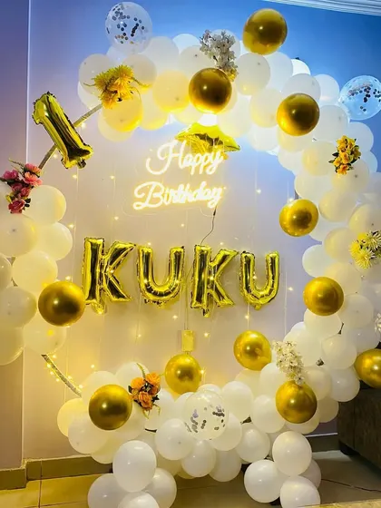 A beautiful white and gold balloon ring for "Kuku's" 1st birthday, decorated with a neon sign and fairy lights.
