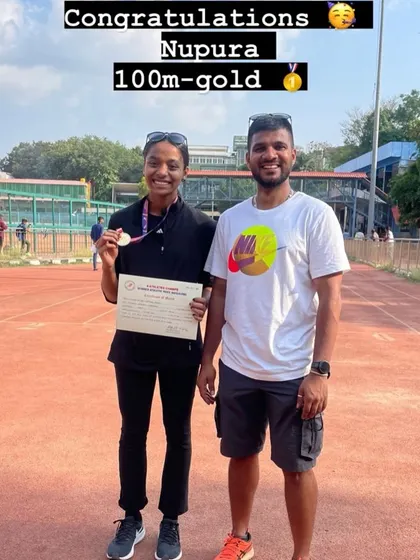 Nupura celebrates her 100m gold medal win at the Summer Athletic Meet alongside her coach.