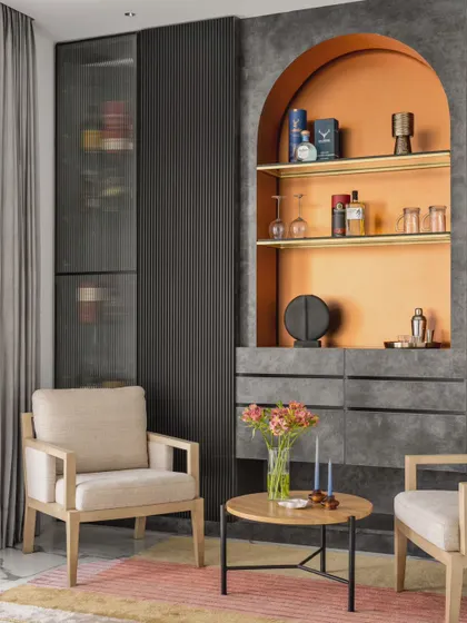 Another view of the lounge, highlighting the custom bar cabinet with its arched, orange-accented niche. This space was designed as a haven for relaxation, with a bold and moody aesthetic.