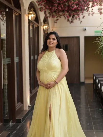 A full-length shot of this glowing mommy-to-be. The makeup is soft and subtle, with a focus on a peachy blush, soft brown eyes, and lots of highlighter to enhance her charm.