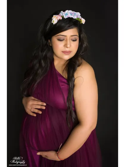 A serene and gentle portrait. The floral headband and soft expression create a peaceful and beautiful image, with all the focus on the mom-to-be.