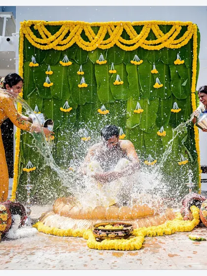 An action shot from a Haldi ceremony, with water being joyfully splashed on the groom. These dynamic photos capture the unrestrained fun of pre-wedding events.