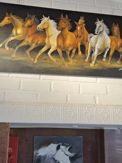 A powerful painting of seven running horses, a significant symbol in Vaastu for bringing success and forward momentum. This piece is displayed in our gallery, showcasing the dynamic energy our artists can capture.