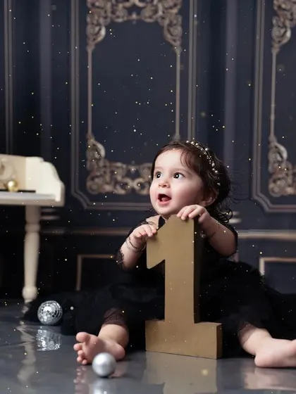 Reaching for the stars, and the number one! An adorable shot from an elegant first birthday session.
