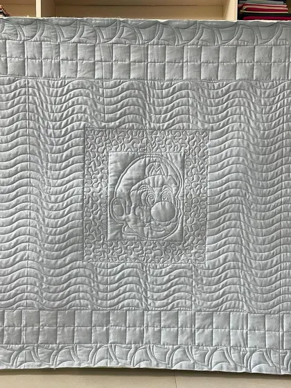 The back of the Mario quilt, where you can see the traced outline of Mario and the different quilting textures.