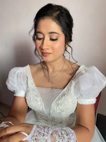 The bride looks down, showcasing the soft, neutral eyeshadow and delicate lashes.