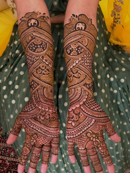 This is a very dense, full-coverage design where the main highlight is the flow of the patterns. You can see a small, auspicious elephant motif at the top of each arm.