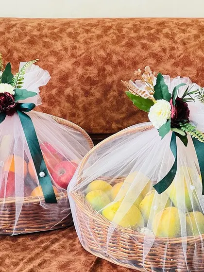 A pair of matching fruit baskets, elegantly wrapped and ready to be gifted. This is a simple yet beautiful gesture for any wedding celebration.