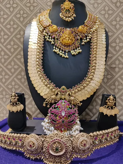 A grand kasulaperu (coin haram) set with a Navratna-style pendant, combining two classic designs.