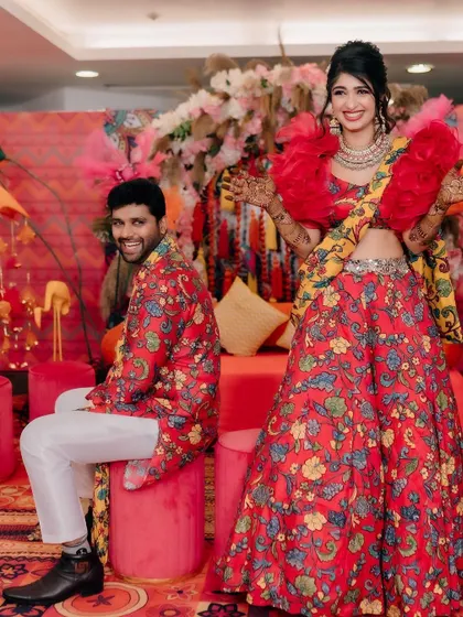 The couple posing against the backdrop of their colourful Mehendi decor. The combination of bright florals, quirky props, and comfortable seating makes for great photos and happy clients.