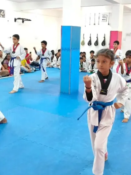 Students practicing their forms, which include various kicks.