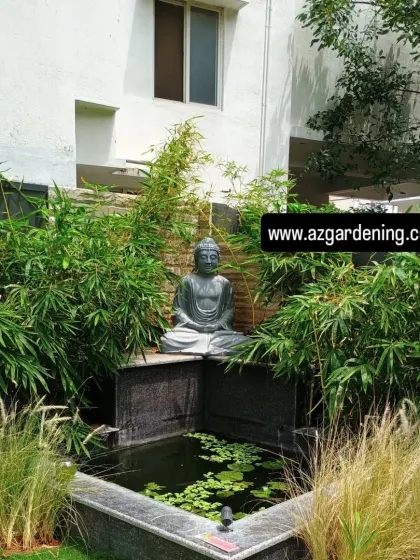 Our granite pond has a Buddha statue above the water, with bamboo behind it and water lilies across the surface.