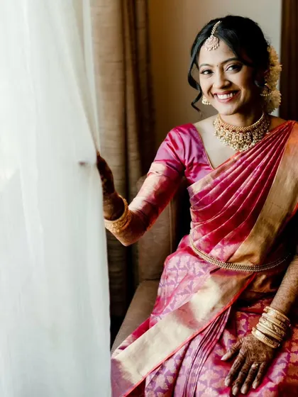 A beautiful shot of a South Indian bride by the window. The natural light highlights her glowing skin and the rich color of her silk saree.
