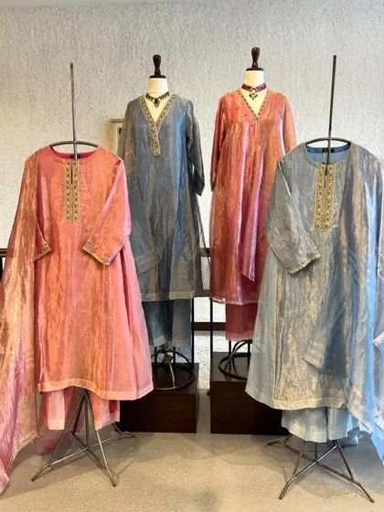 Elegance in every thread. This display features beautiful crushed silk kurta sets in soft shades of pink and blue, perfect for a sophisticated daytime event.