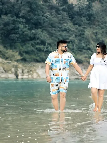 A serene moment as a couple wades into the gentle waters of the Ganga. This type of shot adds a peaceful and grounded element to a pre-wedding collection.