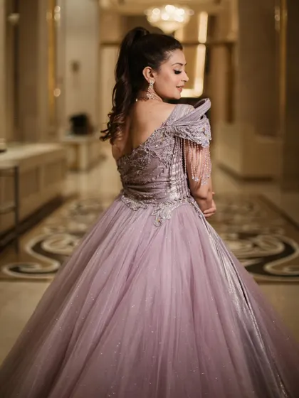 The back view of our royal lavender ball gown, showcasing the asymmetrical design and the beautiful way the silver embroidery wraps around the bodice.