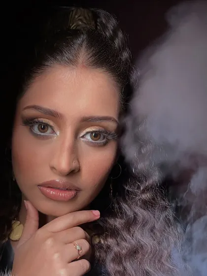 This shot incorporates smoke to add atmosphere, demonstrating how the makeup holds its own and contributes to the overall mood of a creative photoshoot.