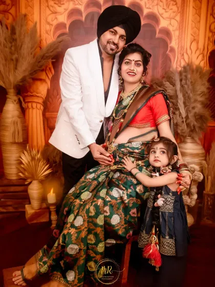 A beautiful family portrait during a traditional maternity shoot. The mother-to-be wears an elegant saree, celebrating her pregnancy alongside her husband and young daughter.