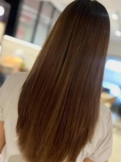 A classic face-framing layered cut paired with a two-tone highlight blend. This look, styled straight, is chic, polished, and timeless.
