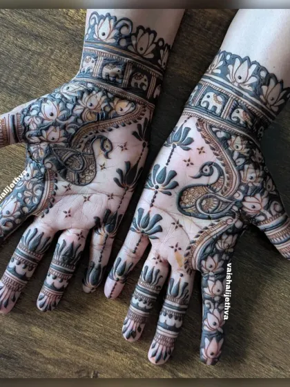 A beautiful negative space design. The dark-filled background makes the peacock, lotus, and elephant motifs pop, creating a stunning visual contrast.