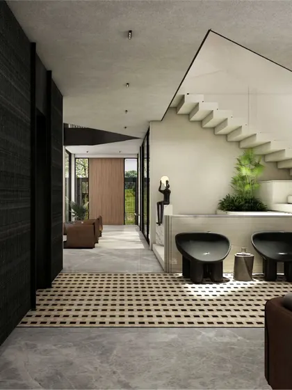 This entrance hall features a striking monochrome tiled floor that creates a rhythmic pattern. The clean lines of the white staircase are softened by curated greenery, while expansive glazing connects the space to the outdoors.