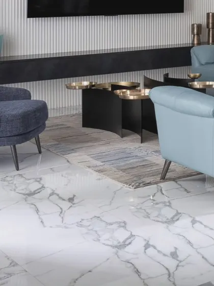 A detail shot of the living room floor, where the abstract rug meets the elegant white marble with grey veining. This highlights our focus on layering textures to create visual interest.