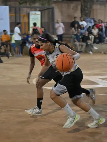 Fierce competition in our women's division. A player drives past the defense for a tough layup, showcasing the skill and intensity of our women's games.