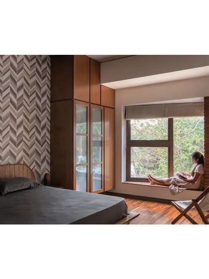 An integrated bedroom solution featuring a custom wooden wardrobe with glass panels, a low-profile bed with a matching headboard, and a built-in window seat. This project shows how we design furniture to fit the architecture and use of a space.